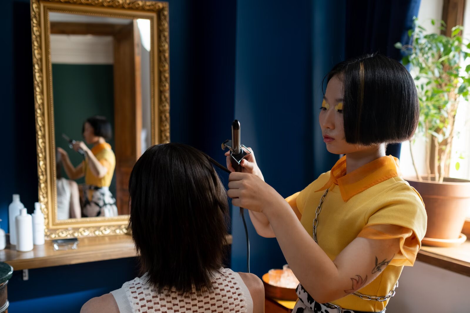 Stylist using curling iron on client