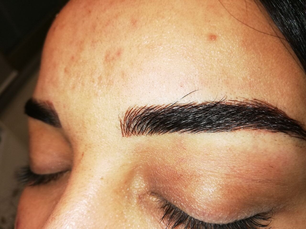 Close-up of perfectly shaped eyebrow showing microblading results