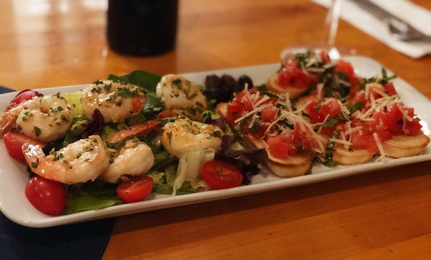 Antipasti platter with garlic prawns on salad and tomato-parmesan bruschetta