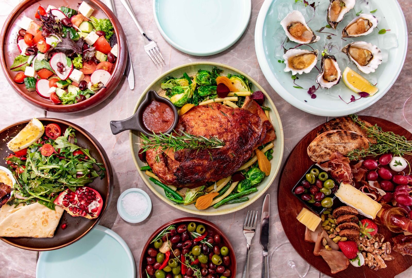 Evening sharing plates with salads, roast, charcuterie and olives