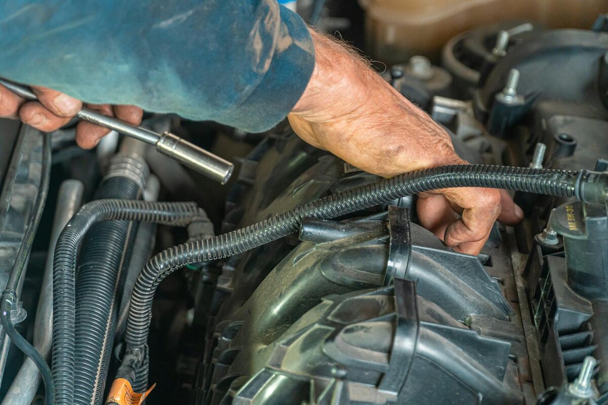 Mechanic performing detailed engine diagnostics on luxury vehicle